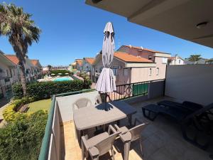 a patio with a table and an umbrella on a balcony at Polena Residence Hotel in Marina di Montenero