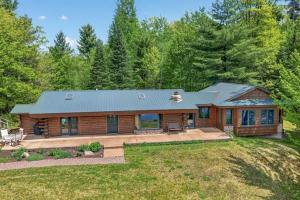a log cabin with a porch and a yard at Lang Lodge cabin in Drummond