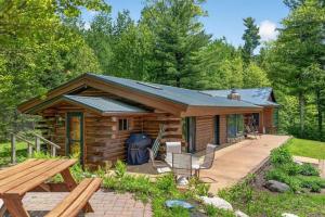a log cabin with a picnic table and a bench at Lang Lodge cabin in Drummond