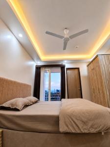 a bedroom with a bed with a ceiling fan at Hotel Silver Oak in Dehradun