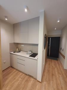 a kitchen with white cabinets and a sink at Omega Dom in Vrnjačka Banja +21 photos