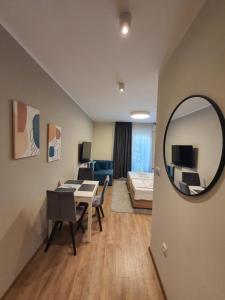 a living room with a table and a mirror at Omega Dom in Vrnjačka Banja