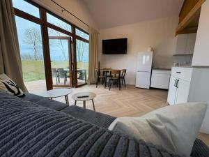 a bedroom with a bed and a kitchen and a table at Apartamenty Mazury in Mikołajki