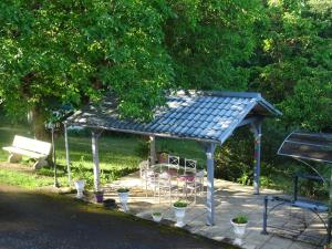 a gazebo with a table and chairs under it at La Clef De Voute Amethyste in Saint-Genest