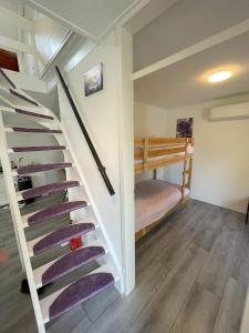 a staircase in a room with a bunk bed at Het lila huisje in Herkingen