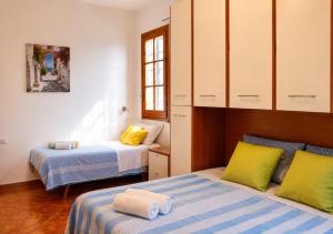 a bedroom with two beds with yellow and blue at Monte Cuccu Bed & Breakfast in Cerfignano