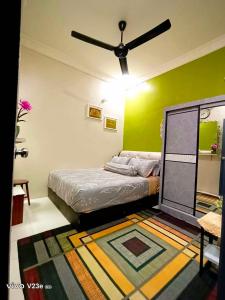 a bedroom with a bed and a ceiling fan at HANS HOMESTAY in Lumut
