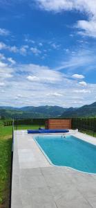 a swimming pool with a view of the mountains at Chatki Niwki u Zbója in Krościenko