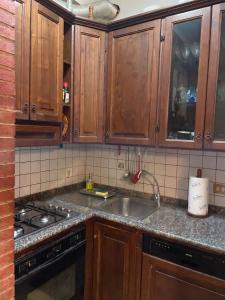a kitchen with wooden cabinets and a sink at Tra le vie di Todi in Todi +12 photos