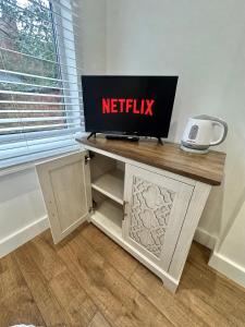 a desk with a netflix sign on top of it at Kettering Railway Lodge in Kettering