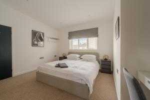 a white bedroom with a bed and a window at Ebenezer Hall in Falmouth