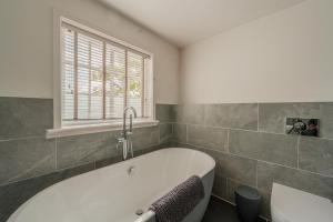 a bathroom with a bath tub and a window at Ebenezer Hall in Falmouth +37 photos