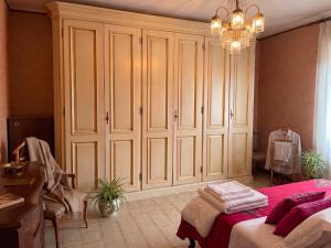 a bedroom with white cabinets and a bed and a chandelier at Tra le vie di Todi in Todi