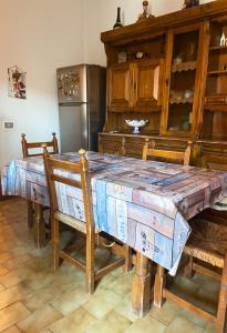 a kitchen with a wooden table with chairs and a refrigerator at Tra le vie di Todi in Todi