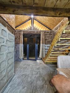 a living room with a stone wall and stairs at Old Goris Hotel in Goris