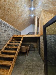 a staircase in a room with a table and a stone wall at Old Goris Hotel in Goris +1 photo