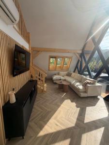 a large living room with a couch and a tv at Noora Nook in Sadu