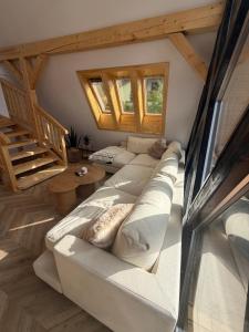 a living room with a white couch and wooden floors at Noora Nook in Sadu +33 photos