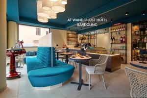an empty restaurant with a blue chair and tables at WANDERLUST VILLETTE a SCHIERA - Bardolino, Lago di Garda - Verona in Bardolino