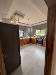 a large kitchen with wooden cabinets and a stove at Good Deeds Realty in Elmina