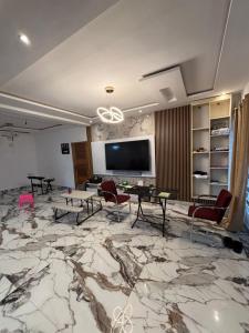 a living room with a large marble floor with a tv at Good Deeds Realty in Elmina
