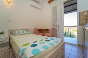 a bedroom with a bed and a balcony at Protić Apartments in Vela Luka