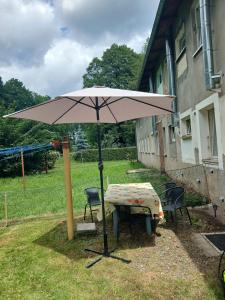 a table and an umbrella in a yard at TANIE NOCLEGI u WOJTKA in Cieplice Slaskie Zdroj