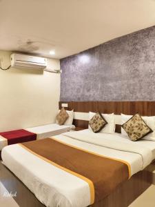a hotel room with two beds and a wall at AA Grand in Hyderabad