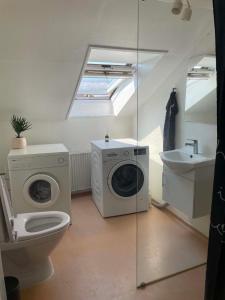 a bathroom with a washing machine and a sink at Stokbrogade 7 - lejlighed 2 in Hjørring