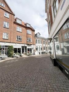 a cobblestone street in a city with tall buildings at Stokbrogade 7 - lejlighed 2 in Hjørring