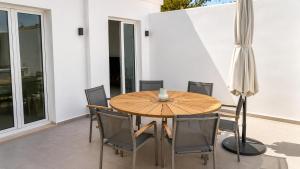 a dining room with a wooden table and chairs at Ela Mare Sea View Apartments in Malia +10 photos