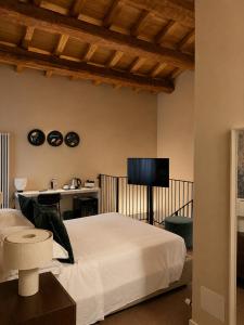 a bedroom with a bed and a tv on the wall at Albergo Diffuso Ginevra Boutique Rooms - Palazzo Leosini - Residenze D'Epoca in LʼAquila