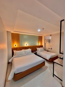 a hotel room with two beds in a room at Hotel Rodolfo in Tacloban