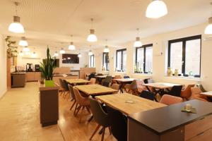 a restaurant with wooden tables and chairs and windows at alla Papa in Obernzenn