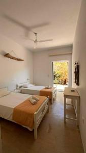 a large bedroom with two beds and a window at Ellia Mirtiotissa Rooms in Glyfada