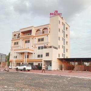 a white building with a sign on top of it at JB Resort in Mhow