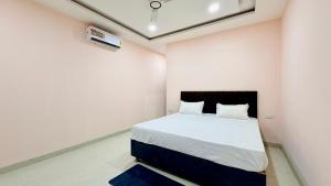 a bedroom with a bed with white walls at JB Resort in Mhow