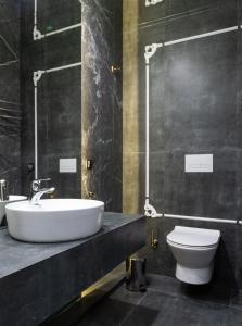 a bathroom with a white sink and a toilet at Hotel Airport Elite Suit Near Delhi Airport in New Delhi +17 photos