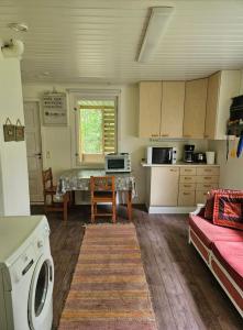 a kitchen with a table and a washing machine at Mänttä Tammirannantie in Mustalahti