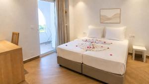 a bedroom with a large white bed with flowers on it at Ela Mare Sea View Apartments in Malia