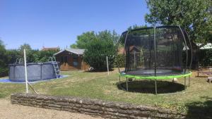 a small playground with a trampoline in a yard at Convivialetzen in Châtenoy-le-Royal