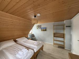 a bed in a room with a wooden ceiling at Gästewohnung in Algermissen in Algermissen