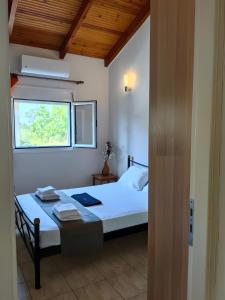 a bedroom with a large bed with a window at Emis house krioneri in Lapanayoí