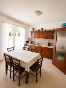a kitchen with a table with chairs and a refrigerator at Croatia Apartman Masa in Senj +28 photos