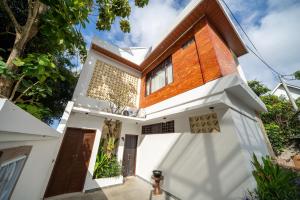 a house with white walls and wooden doors at Uluran Villa Uluwatu in Uluwatu