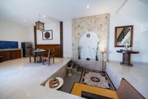 a living room with a couch and a table at Uluran Villa Uluwatu in Uluwatu