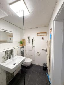 a bathroom with a white sink and a toilet at Gästewohnung in Algermissen in Algermissen +29 photos