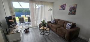 a living room with a couch and a table at Het lila huisje in Herkingen +16 photos