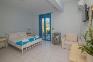 a bedroom with a bed and a couch and a chair at Akrotiri Vasiliki in Vasiliki +34 photos