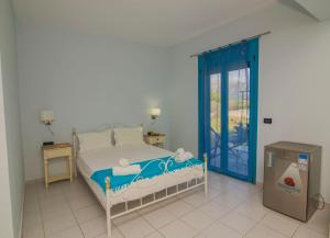 a bedroom with a bed with a blue door at Akrotiri Vasiliki in Vasiliki